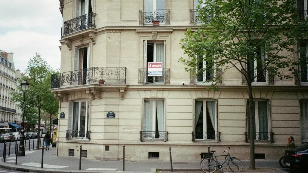 Façade d'immeuble résidentiel français avec panneau à vendre dans un quartier urbain